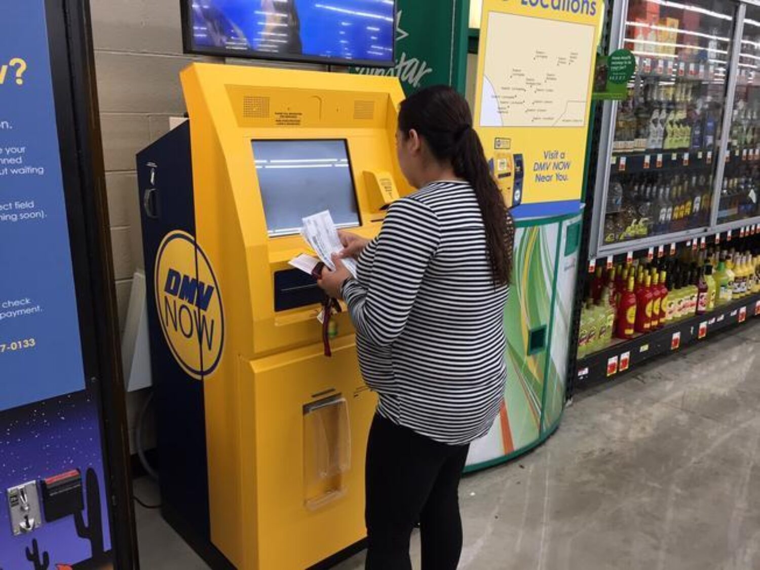 a woman using a dmv self service kiosk