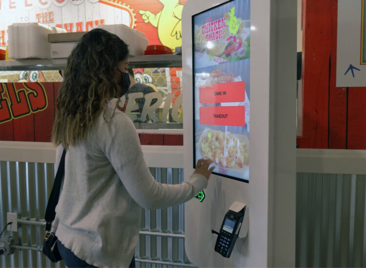 women engaging with quick service restaurant kiosk